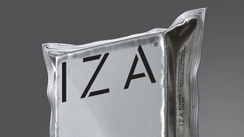 Primer plano del empaque metalizado de IZA con el logotipo en negro
